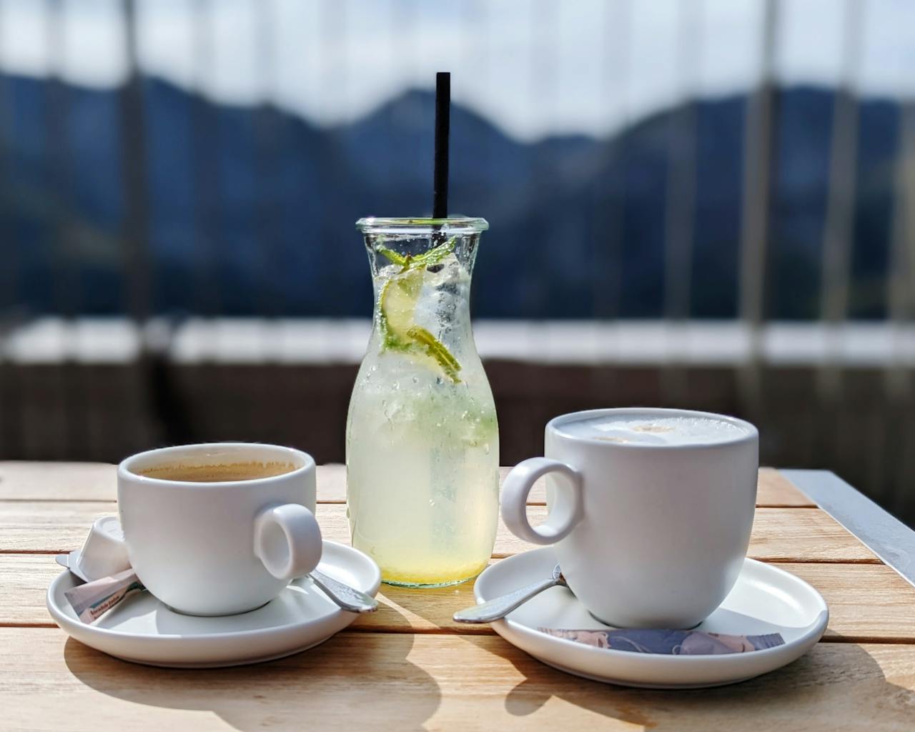 Cozy outdoor scene with coffee and lemonade on a wooden table in Schönau am Königssee.